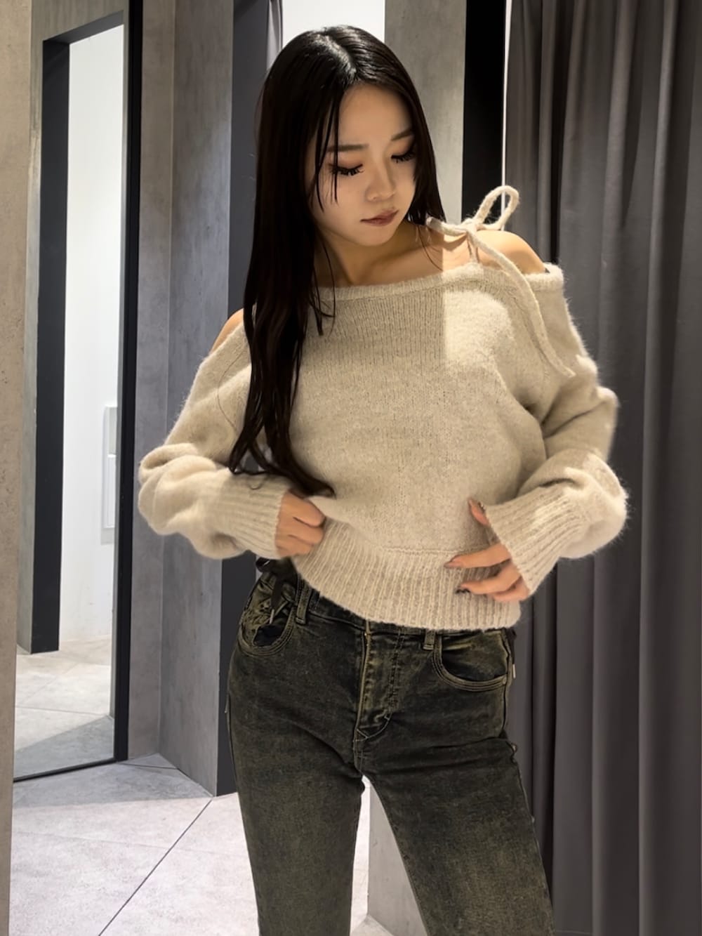 ブラウン系のダウンジャケット/コート、ホワイト系のニット/セーター、ブルー系のデニムパンツを着用したレディースの冬コーディネートの4枚目の写真