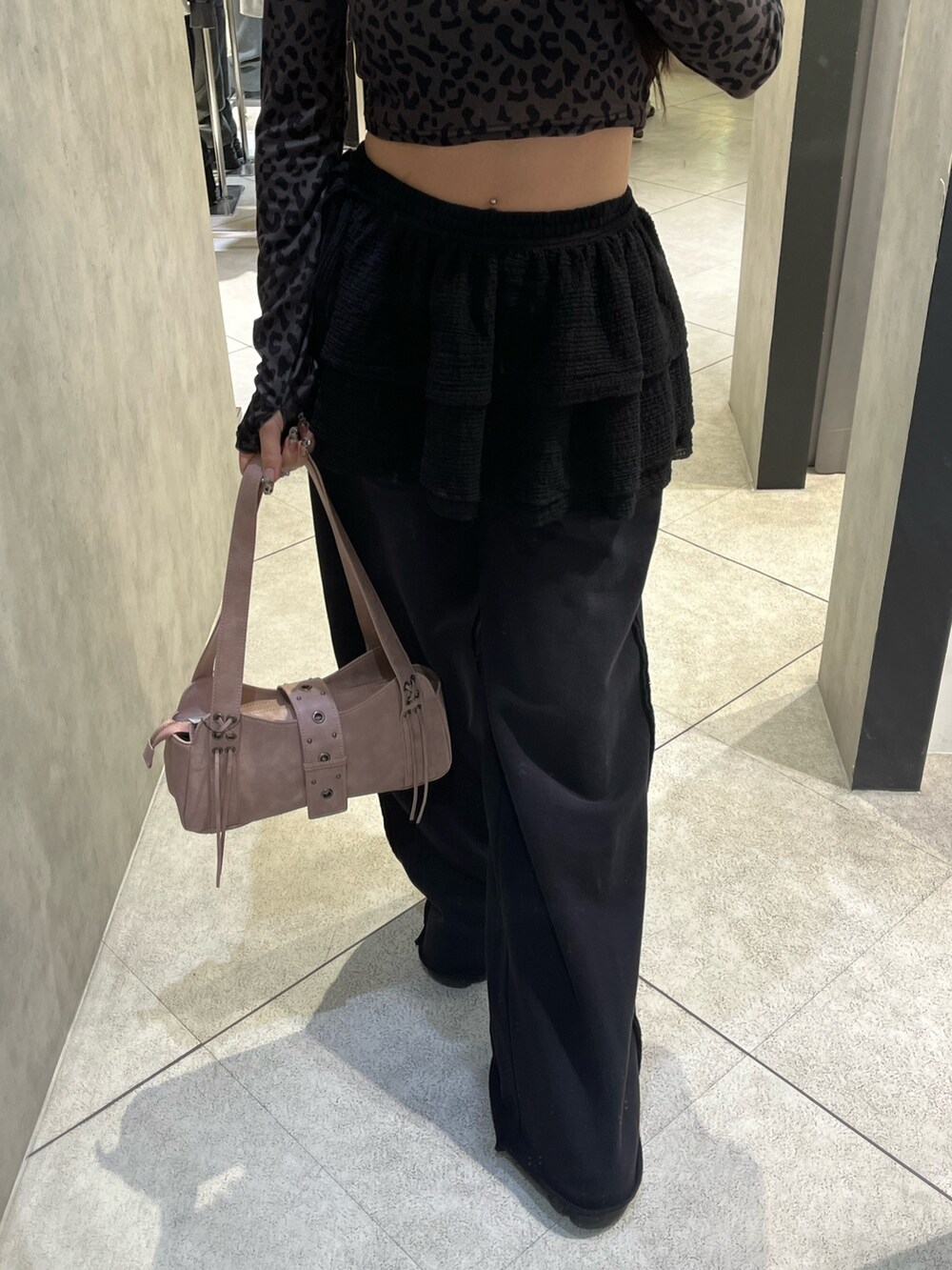 ブラック系のスカート、ブラック系のスウェットパンツ、ピンク系のハンドバッグを着用したレディースの秋コーディネートの6枚目の写真