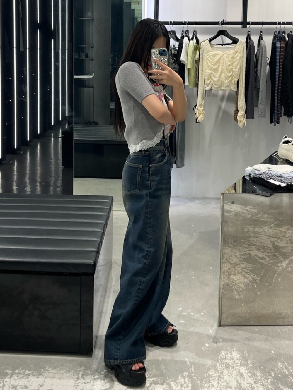 ブルー系のデニムパンツ、グレー系のニット/セーター、ブラック系のサンダルを着用したレディースの春コーディネートの2枚目の写真