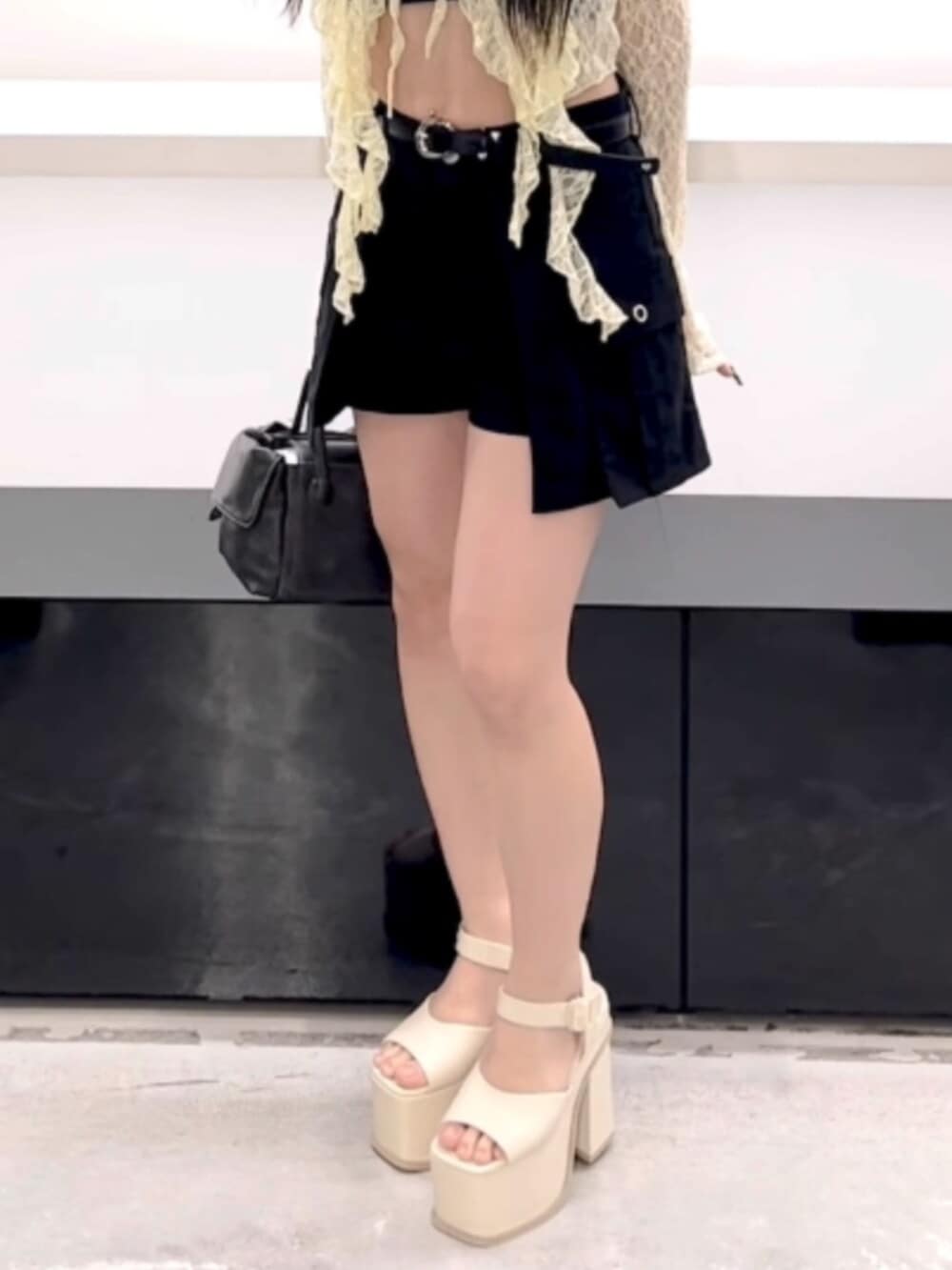 ブラック系のハンドバッグ、ブラック系のスカート、イエロー系のTシャツ/カットソーを着用したレディースの春コーディネートの8枚目の写真