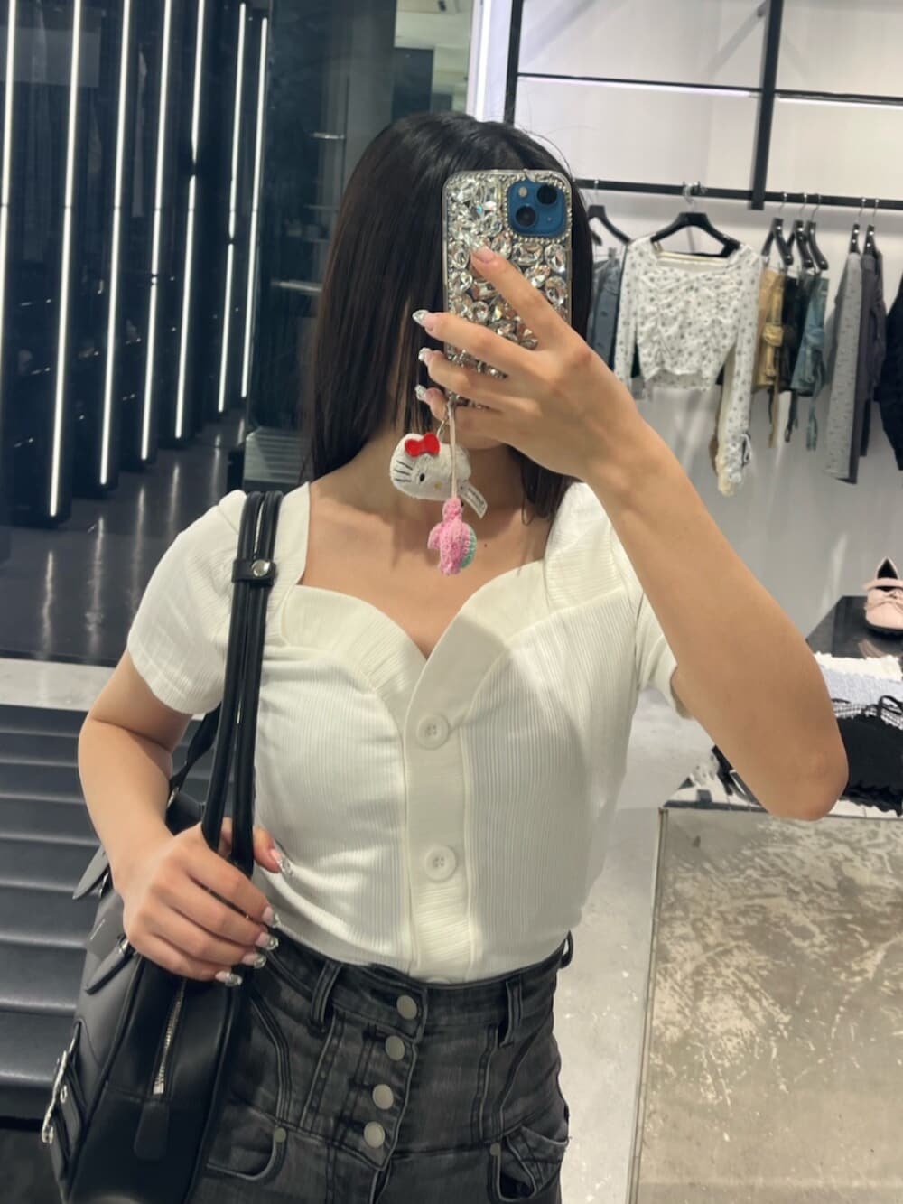 ブラック系のデニムパンツ、ブラック系のサンダル、ホワイト系のTシャツ/カットソーを着用したレディースの春コーディネートの5枚目の写真
