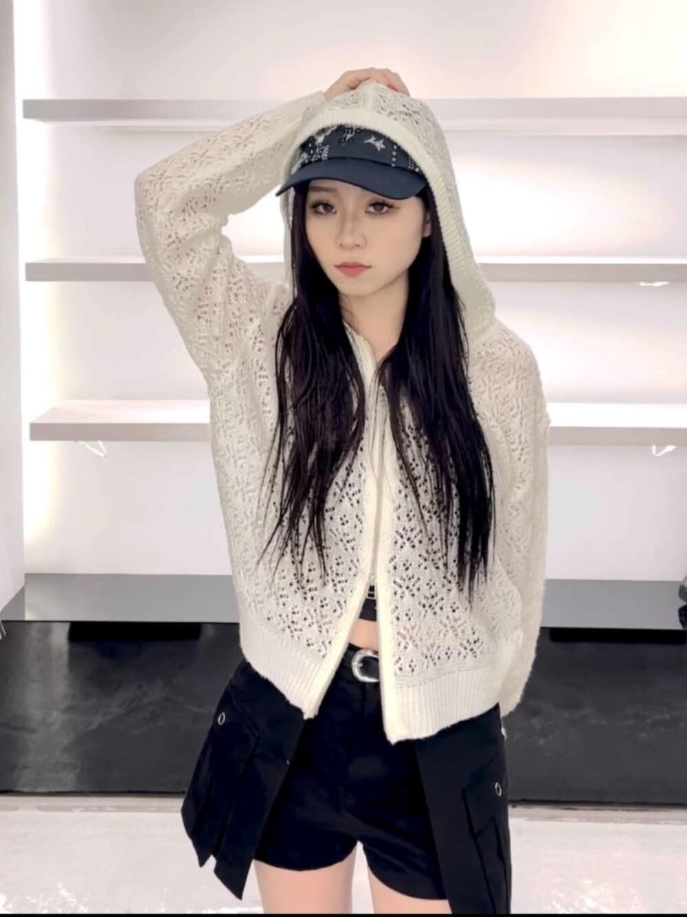 ブラック系のサンダル、ホワイト系のパーカー、ブラック系のスカートを着用したレディースの春コーディネートの6枚目の写真