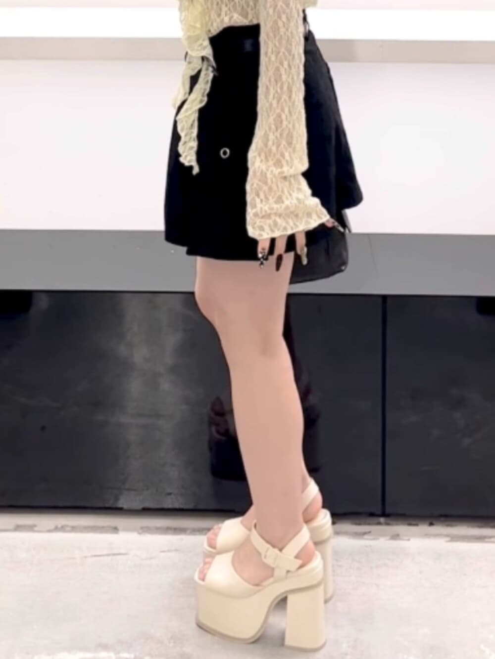 ブラック系のハンドバッグ、ブラック系のスカート、イエロー系のTシャツ/カットソーを着用したレディースの春コーディネートの9枚目の写真