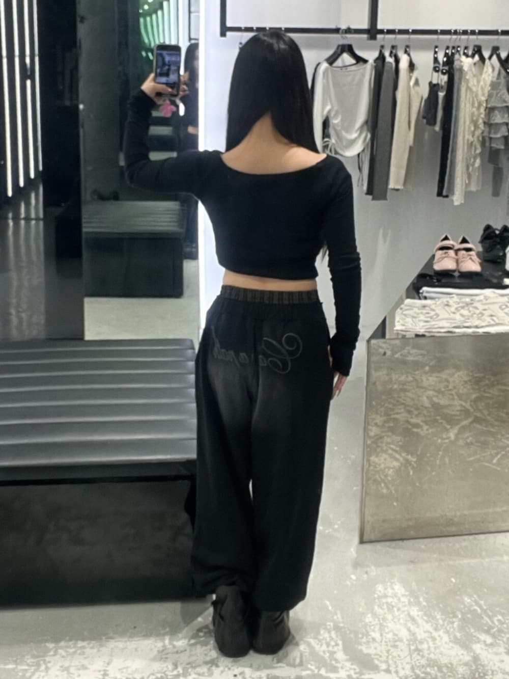 ブラック系のスウェットパンツ、ブラック系のブーツ、ブラック系のTシャツ/カットソーを着用したレディースの春コーディネートの3枚目の写真