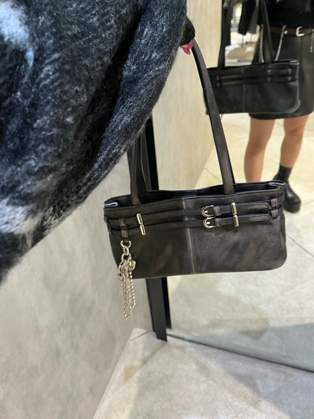 ブラック系のスカート、ブラック系のニット/セーター、ブラック系のショルダーバッグを着用したレディースの秋コーディネートの7枚目の写真