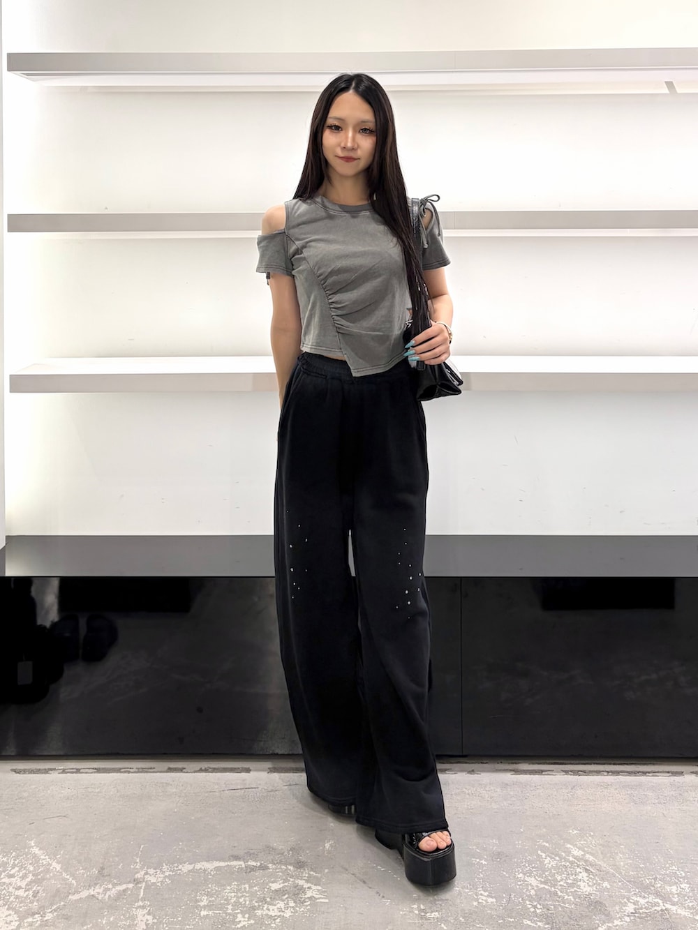 グレー系のTシャツ/カットソー、ブラック系のスウェットパンツ、ブラック系のサンダルを着用したレディースの夏コーディネートの2枚目の写真