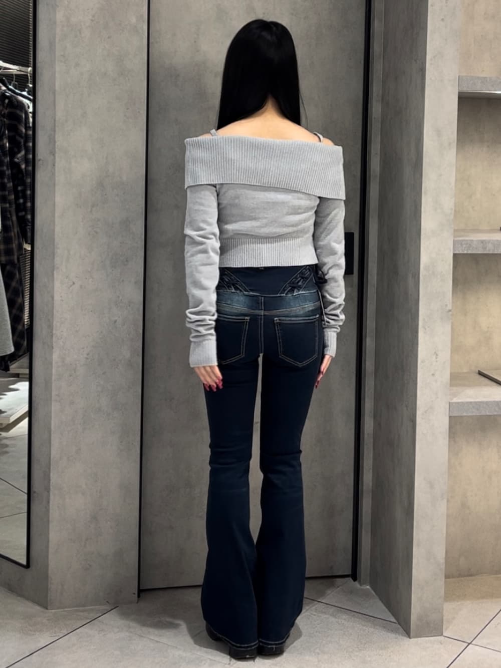 グレー系のニット/セーター、ブルー系のデニムパンツ、ブラック系のブーツを着用したレディースの冬コーディネートの3枚目の写真