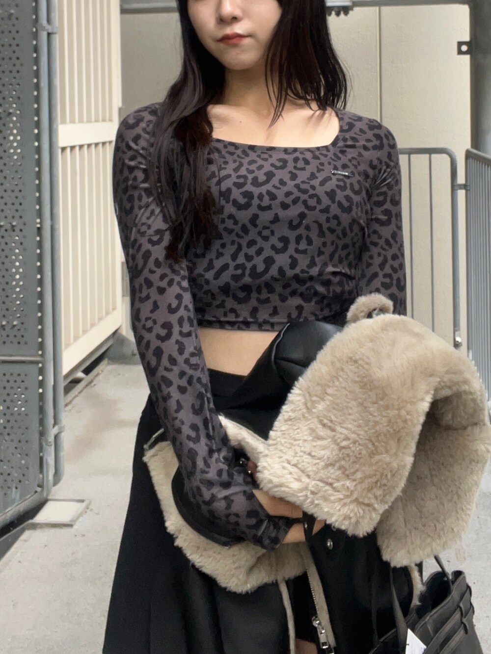 ブラック系のショルダーバッグ、ブラック系のブーツ、ブラック系のスカートを着用したレディースの秋コーディネートの4枚目の写真