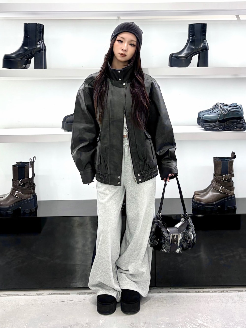 ブラック系のブルゾン、ブラック系のショルダーバッグ、グレー系のその他パンツを着用したレディースの秋コーディネートの2枚目の写真