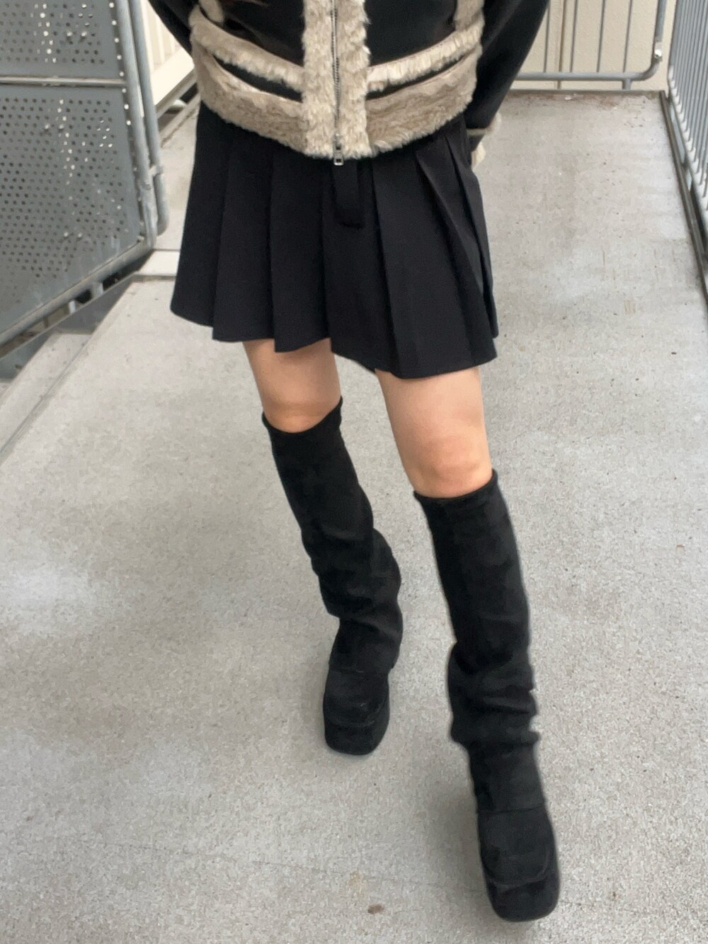 ブラック系のショルダーバッグ、ブラック系のブーツ、ブラック系のスカートを着用したレディースの秋コーディネートの6枚目の写真