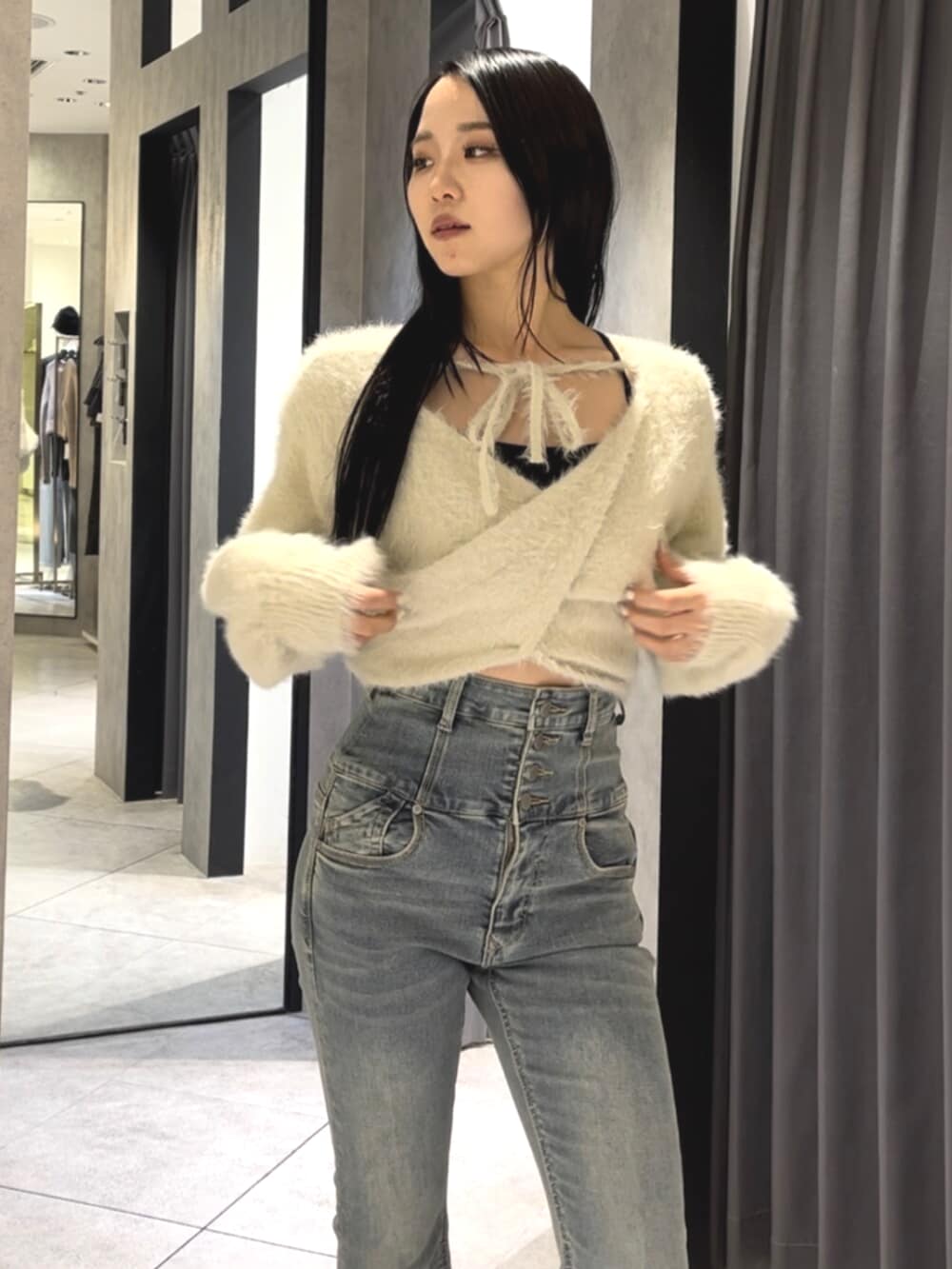 ブルー系のデニムパンツ、ホワイト系のニット/セーター、ブラック系のブーツを着用したレディースの冬コーディネートの4枚目の写真