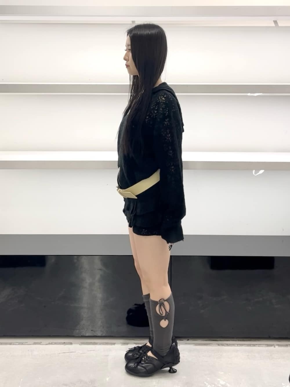 ブラック系のパーカー、ブラック系のスカート、ブラック系のスニーカーを着用したレディースの春コーディネートの3枚目の写真