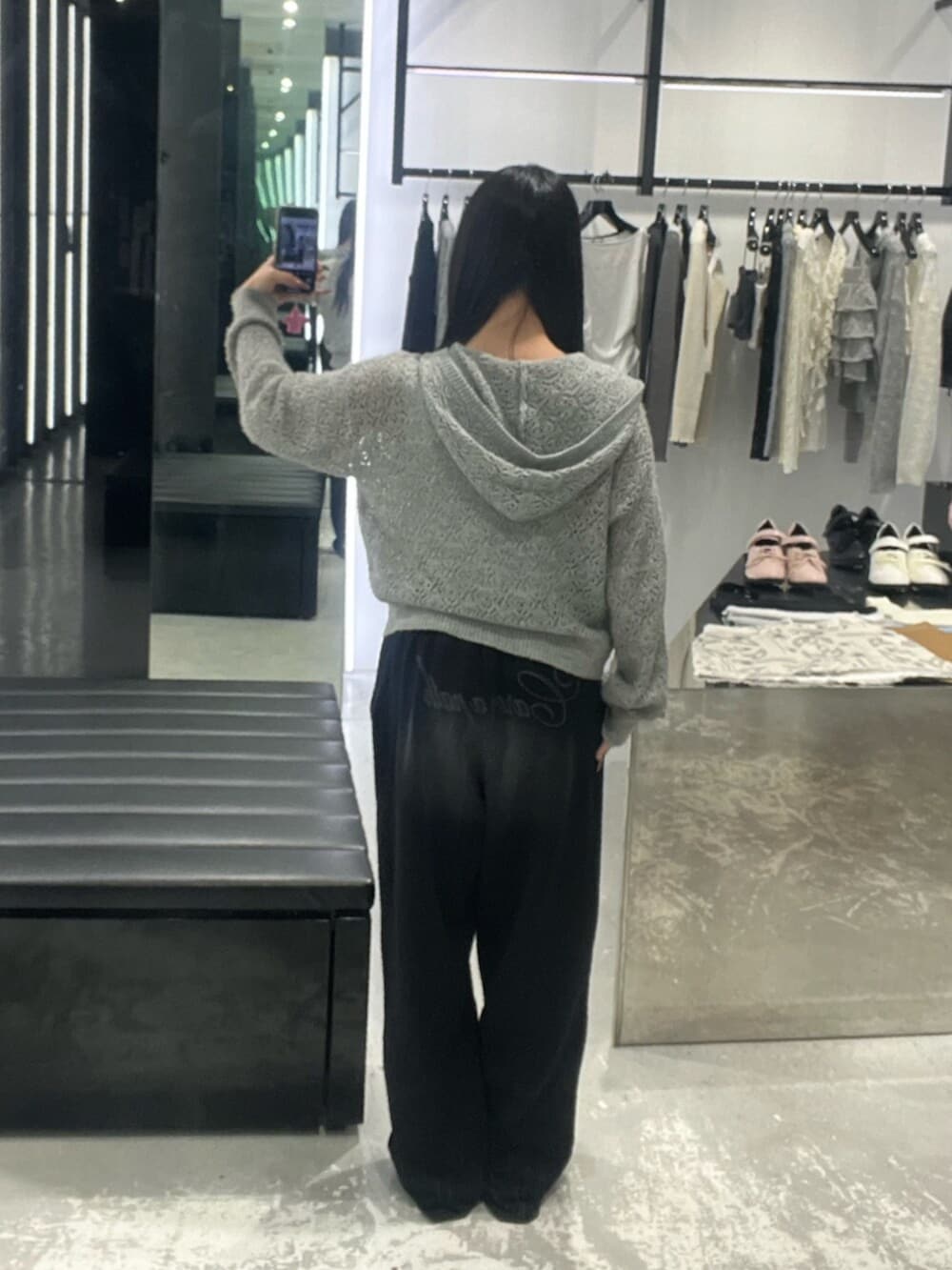 グレー系のパーカー、ブラック系のスウェットパンツ、ホワイト系のニット/セーターを着用したレディースの春コーディネートの4枚目の写真