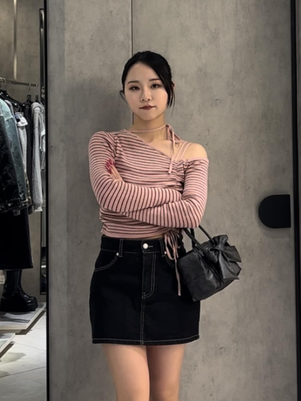 ピンク系のニット/セーター、ブルー系のスカート、ブラウン系のハンドバッグを着用したレディースの冬コーディネートの5枚目の写真