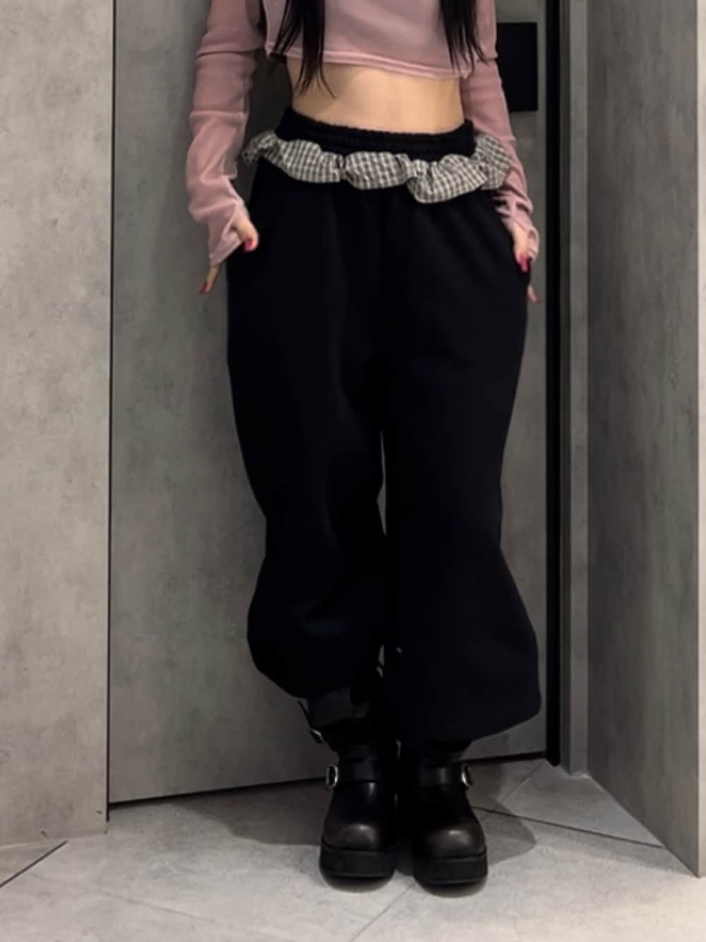 ピンク系のTシャツ/カットソー、ブラック系のスウェットパンツ、ブラック系のブーツを着用したレディースの冬コーディネートの7枚目の写真