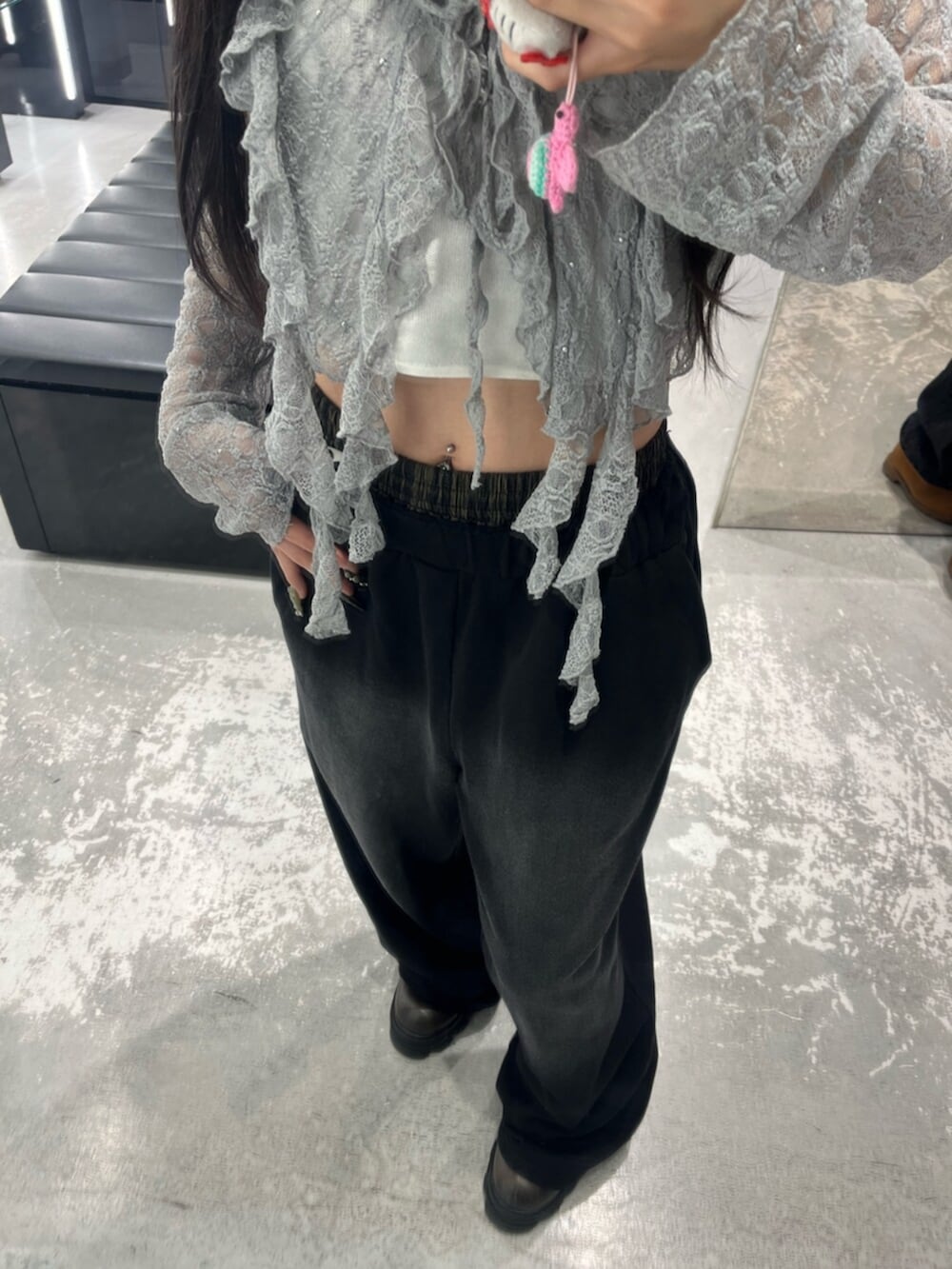 グレー系のTシャツ/カットソー、ブラック系のスウェットパンツ、ホワイト系のニット/セーターを着用したレディースの春コーディネートの6枚目の写真