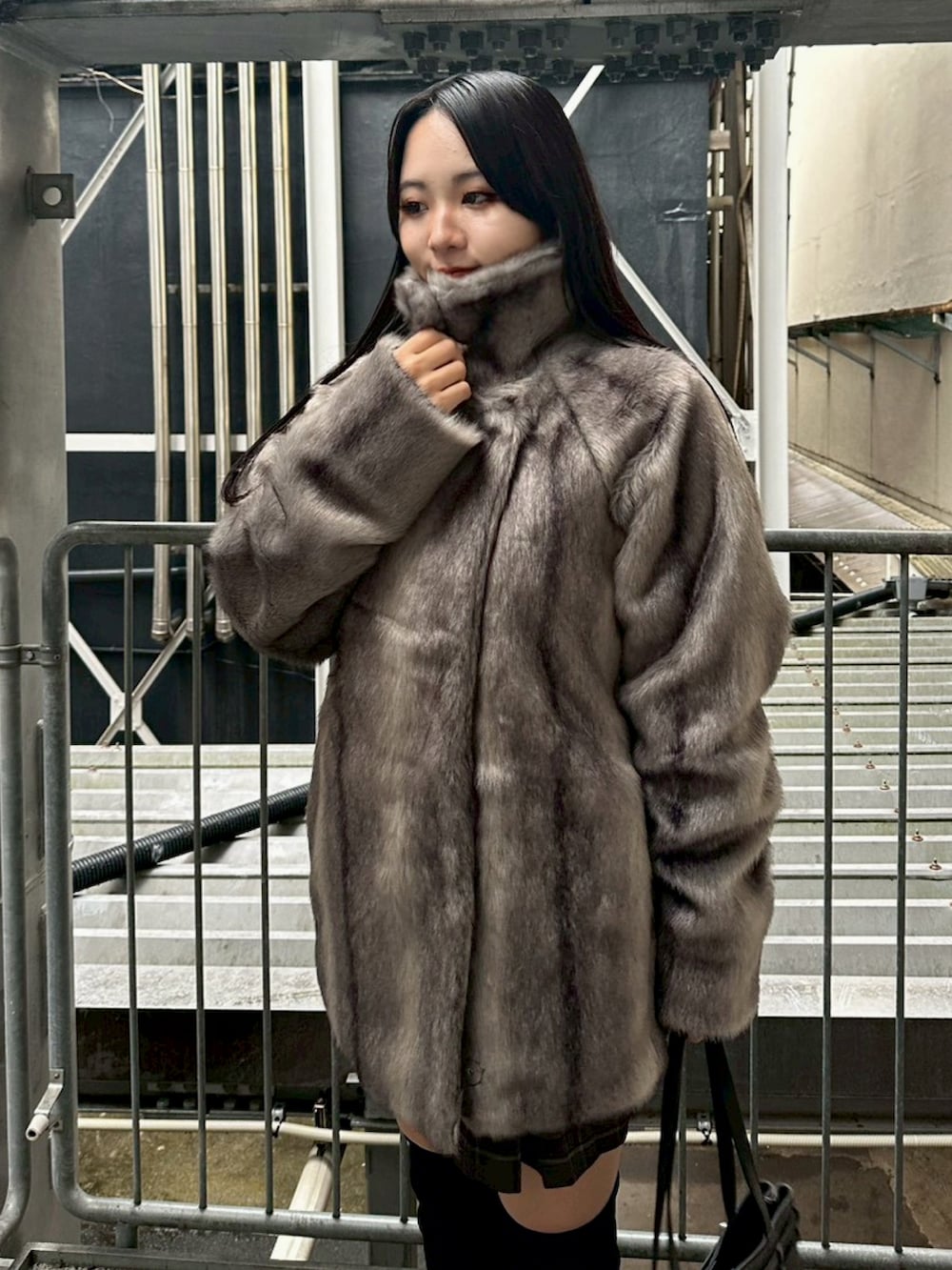 グレー系のその他アウター、ブラック系のニット/セーター、ブラウン系のスカートを着用したレディースの秋コーディネートの7枚目の写真