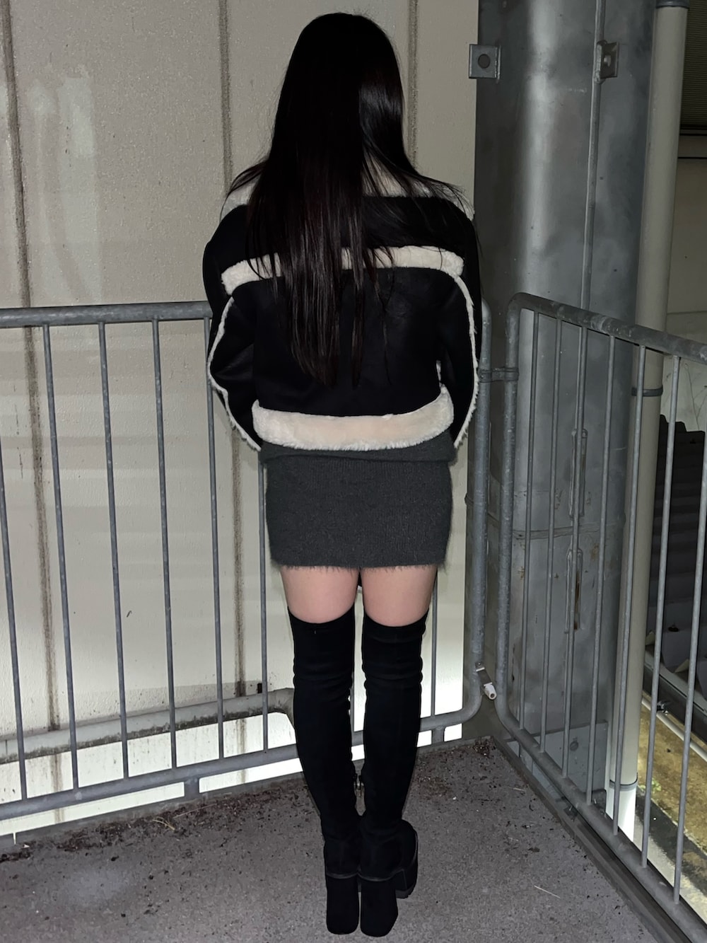 ブラック系のブルゾン、グレー系のワンピース、ブラック系のハンドバッグを着用したレディースの冬コーディネートの4枚目の写真