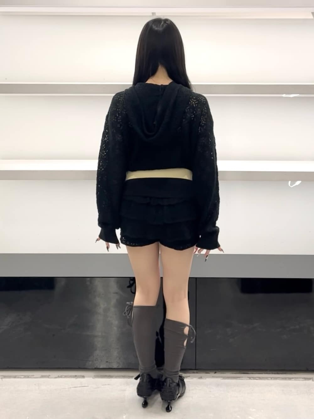 ブラック系のパーカー、ブラック系のスカート、ブラック系のスニーカーを着用したレディースの春コーディネートの4枚目の写真