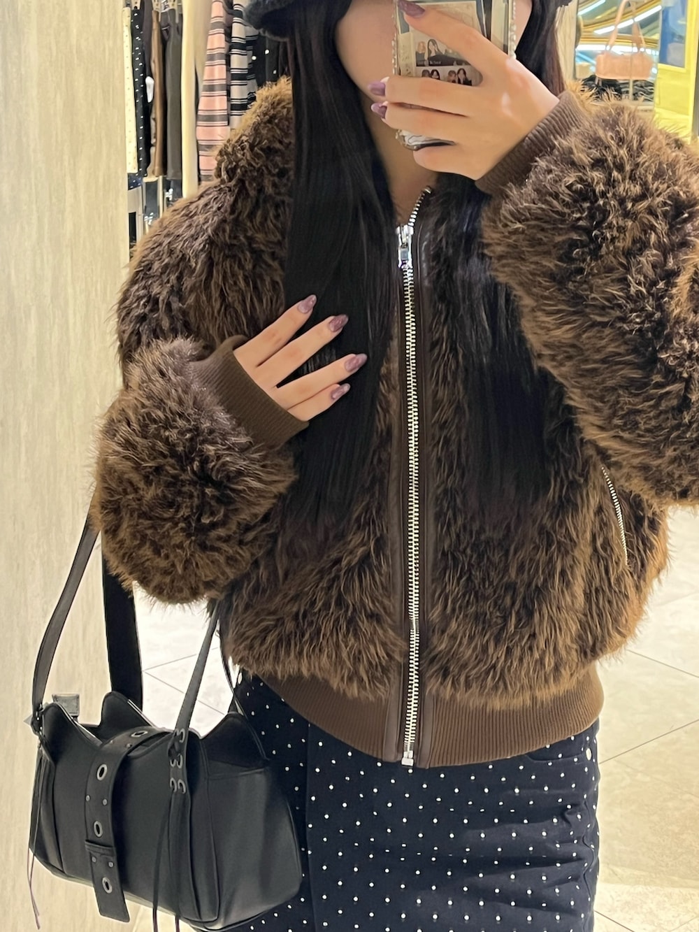 ブラック系のブーツ、ブラック系のハンドバッグ、ブルー系のスカートを着用したレディースの秋コーディネートの9枚目の写真