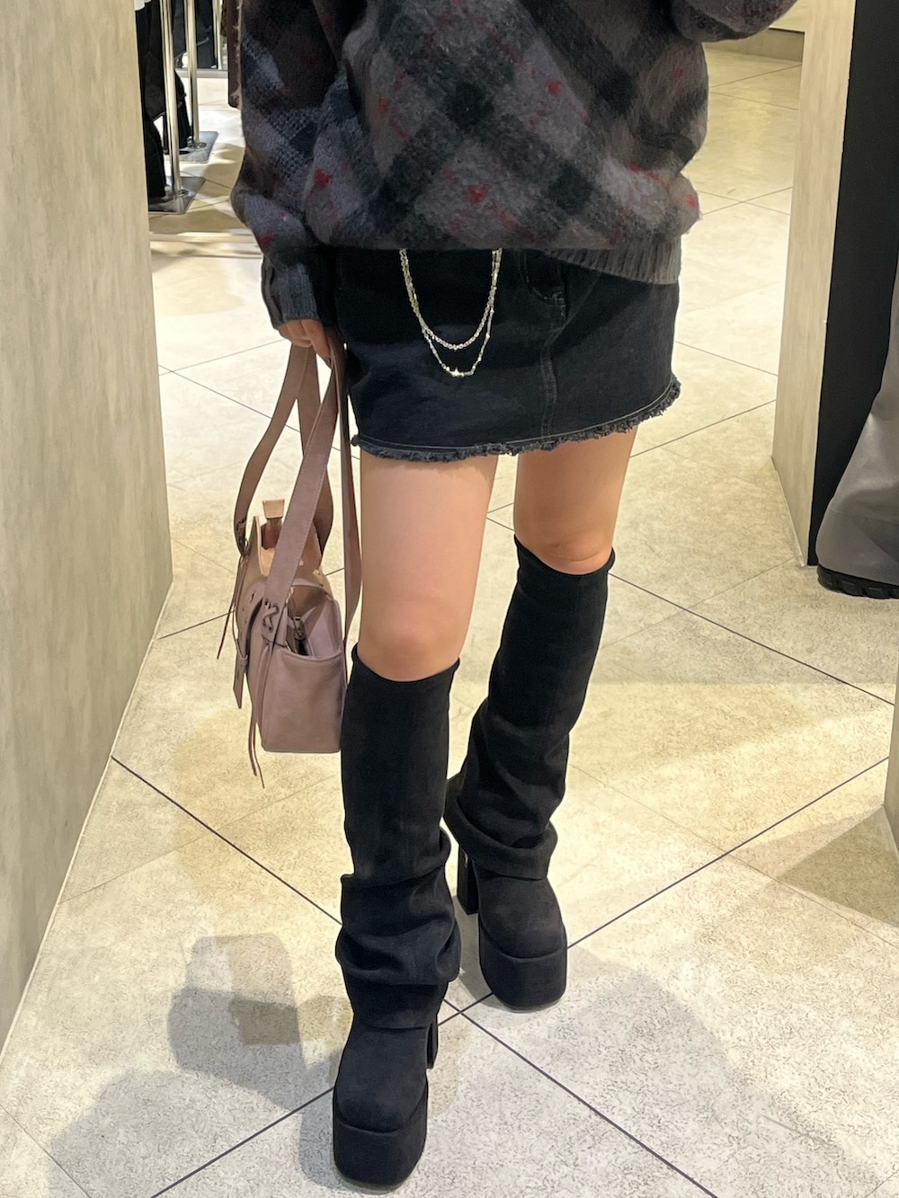 ブラック系のスカート、ピンク系のハンドバッグ、グレー系のニット/セーターを着用したレディースの秋コーディネートの5枚目の写真