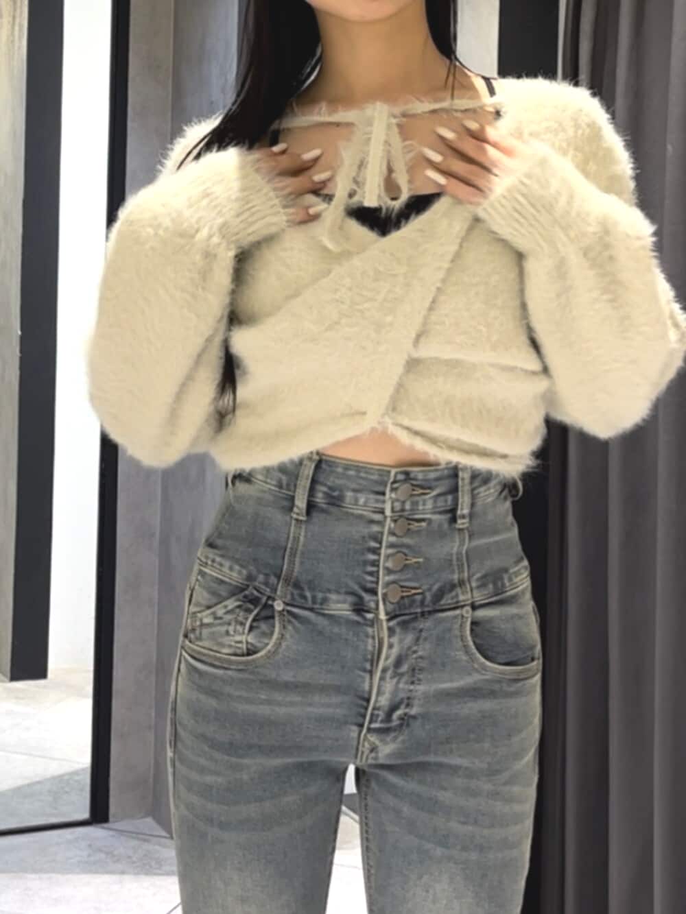 ブルー系のデニムパンツ、ホワイト系のニット/セーター、ブラック系のブーツを着用したレディースの冬コーディネートの6枚目の写真