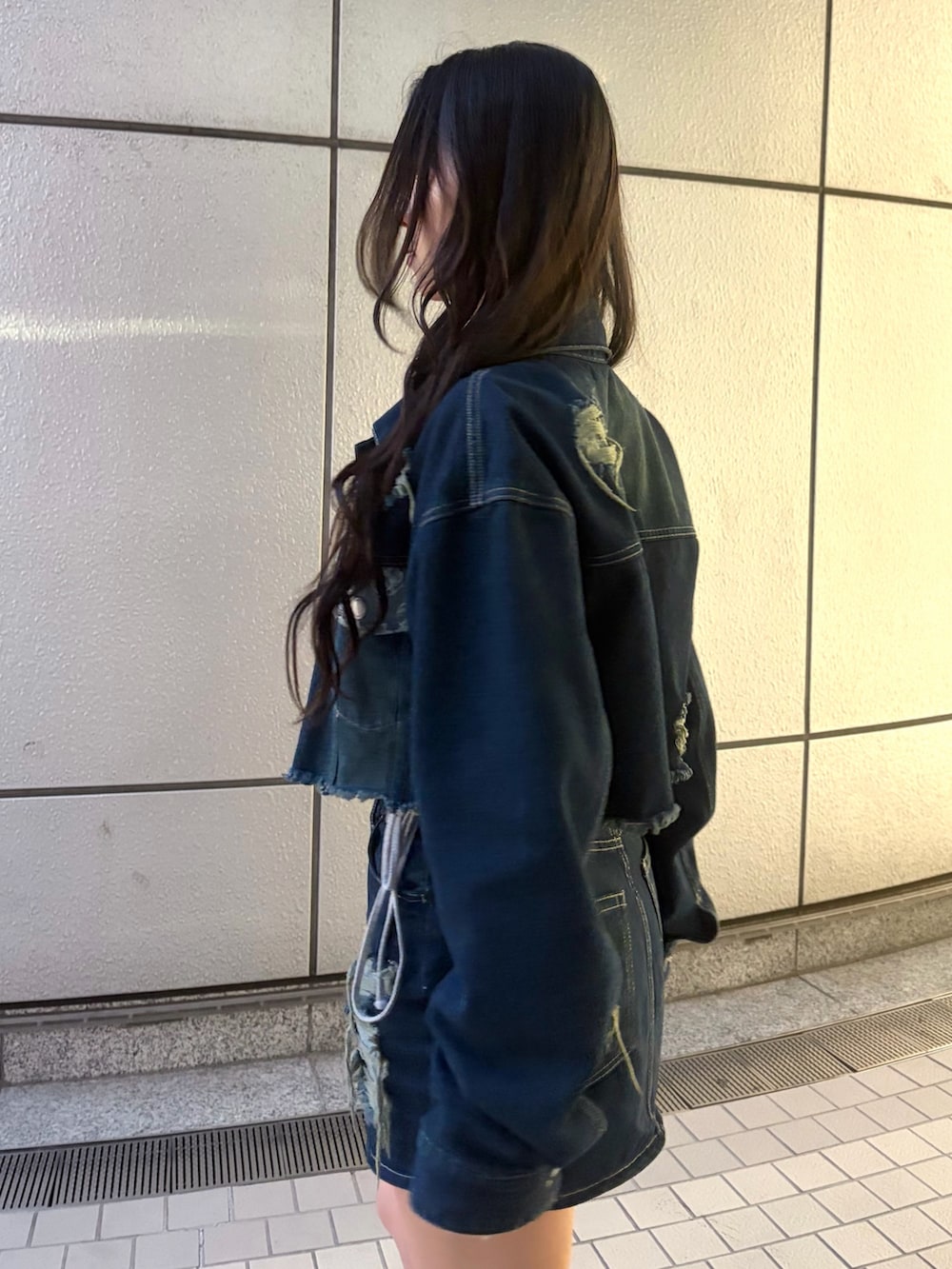 ブルー系のスカート、ブラック系のブーツ、グレー系のTシャツ/カットソーを着用したレディースの秋コーディネートの8枚目の写真
