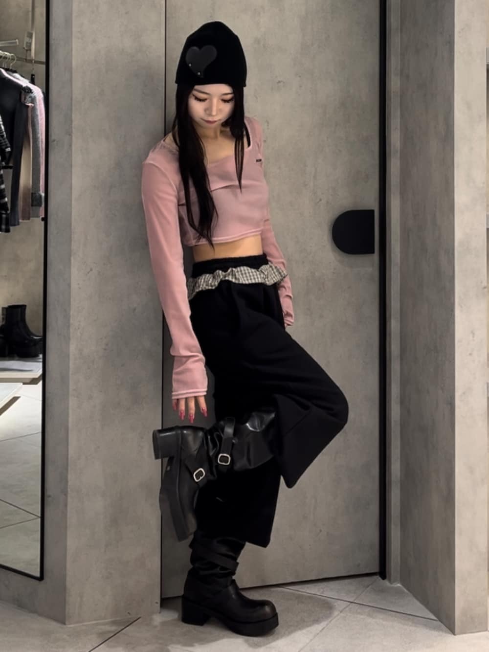 ピンク系のTシャツ/カットソー、ブラック系のスウェットパンツ、ブラック系のブーツを着用したレディースの冬コーディネートの9枚目の写真