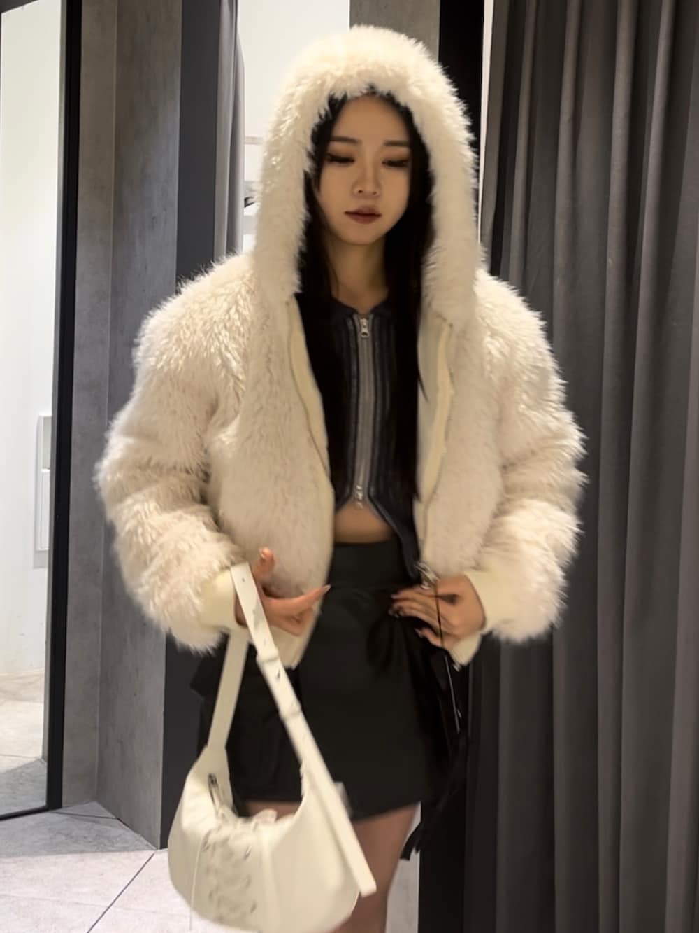 ホワイト系のブルゾン、ブルー系のニット/セーター、ブラック系のその他パンツを着用したレディースの冬コーディネートの6枚目の写真