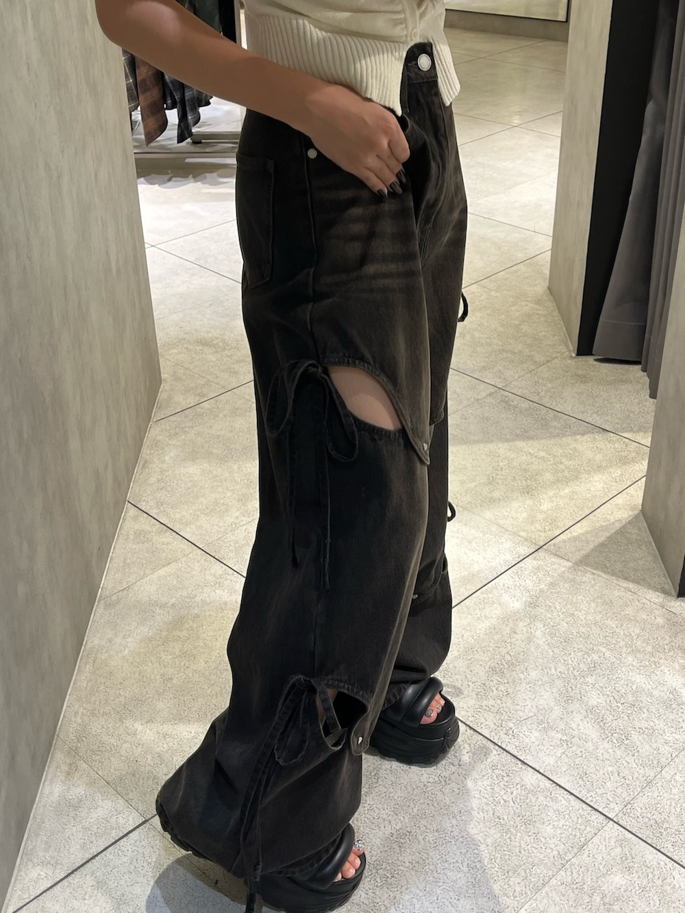 ホワイト系のニット/セーター、ブラック系のデニムパンツ、ブラック系のサンダルを着用したレディースの秋コーディネートの6枚目の写真