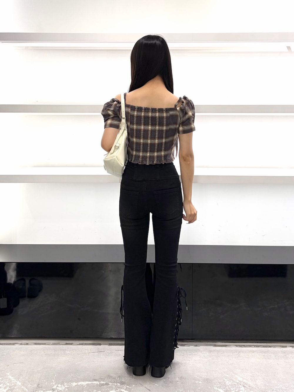 ブラウン系のTシャツ/カットソー、ホワイト系のハンドバッグ、ブラック系のデニムパンツを着用したレディースの夏コーディネートの4枚目の写真