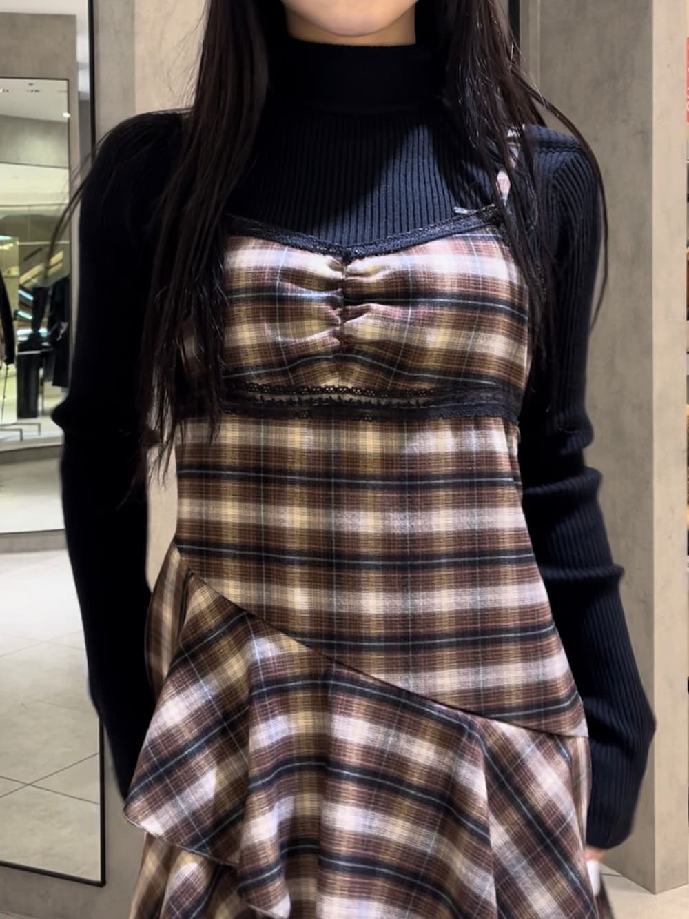 ブラック系のニット/セーター、ベージュ系のワンピース、レッド系のショルダーバッグを着用したレディースの冬コーディネートの7枚目の写真