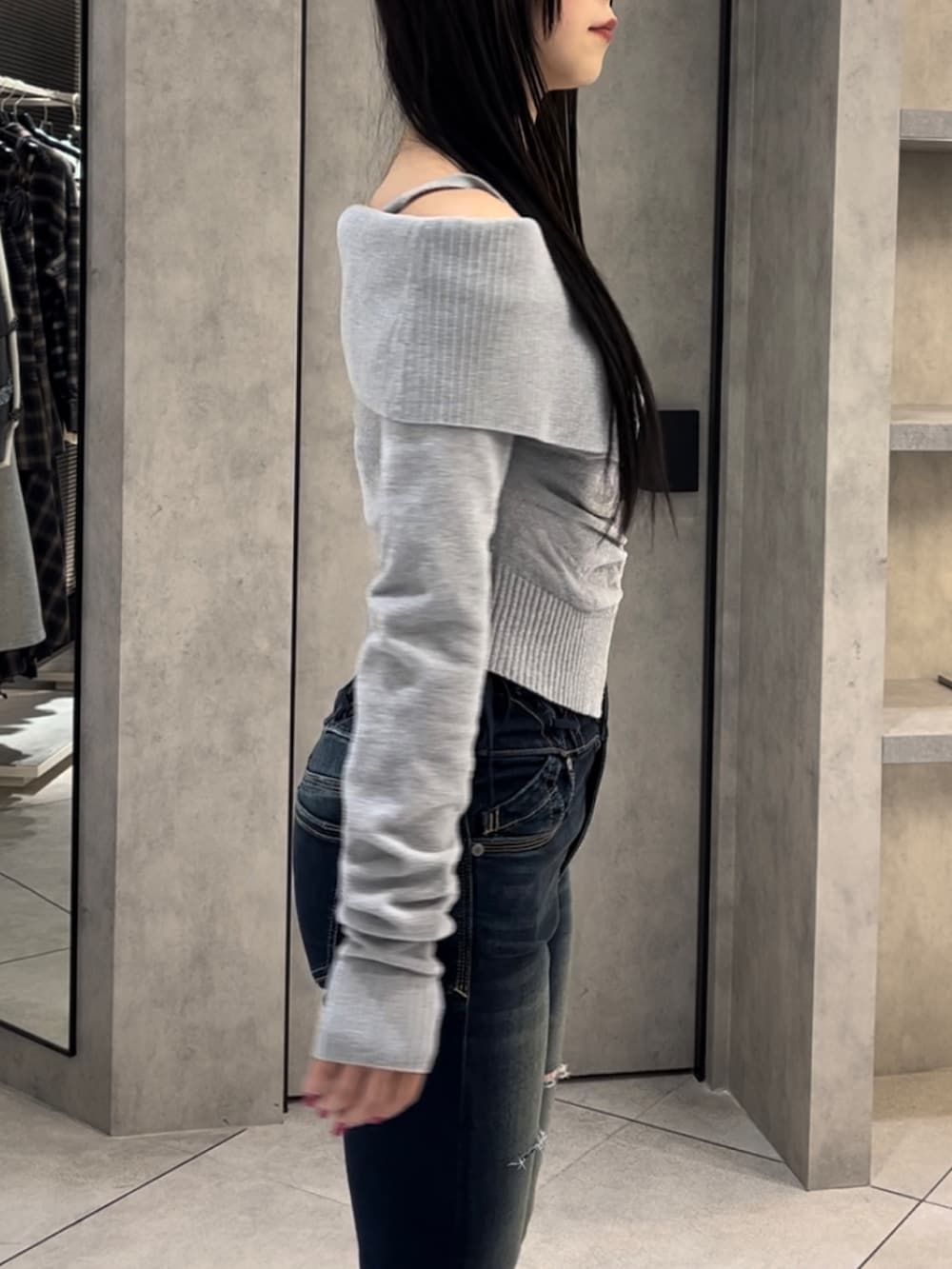 グレー系のニット/セーター、ブルー系のデニムパンツ、ブラック系のブーツを着用したレディースの冬コーディネートの6枚目の写真