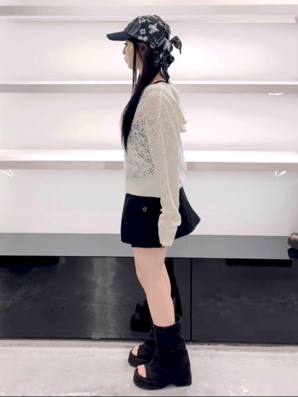 ブラック系のサンダル、ホワイト系のパーカー、ブラック系のスカートを着用したレディースの春コーディネートの3枚目の写真