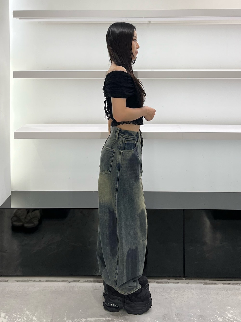 ブラック系のスニーカー、ブルー系のデニムパンツ、ブラック系のTシャツ/カットソーを着用したレディースの夏コーディネートの3枚目の写真