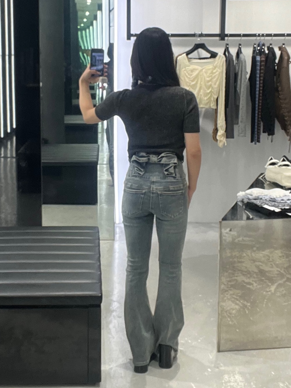 ブラック系のニット/セーター、ブルー系のデニムパンツ、ブラック系のサンダルを着用したレディースの春コーディネートの3枚目の写真