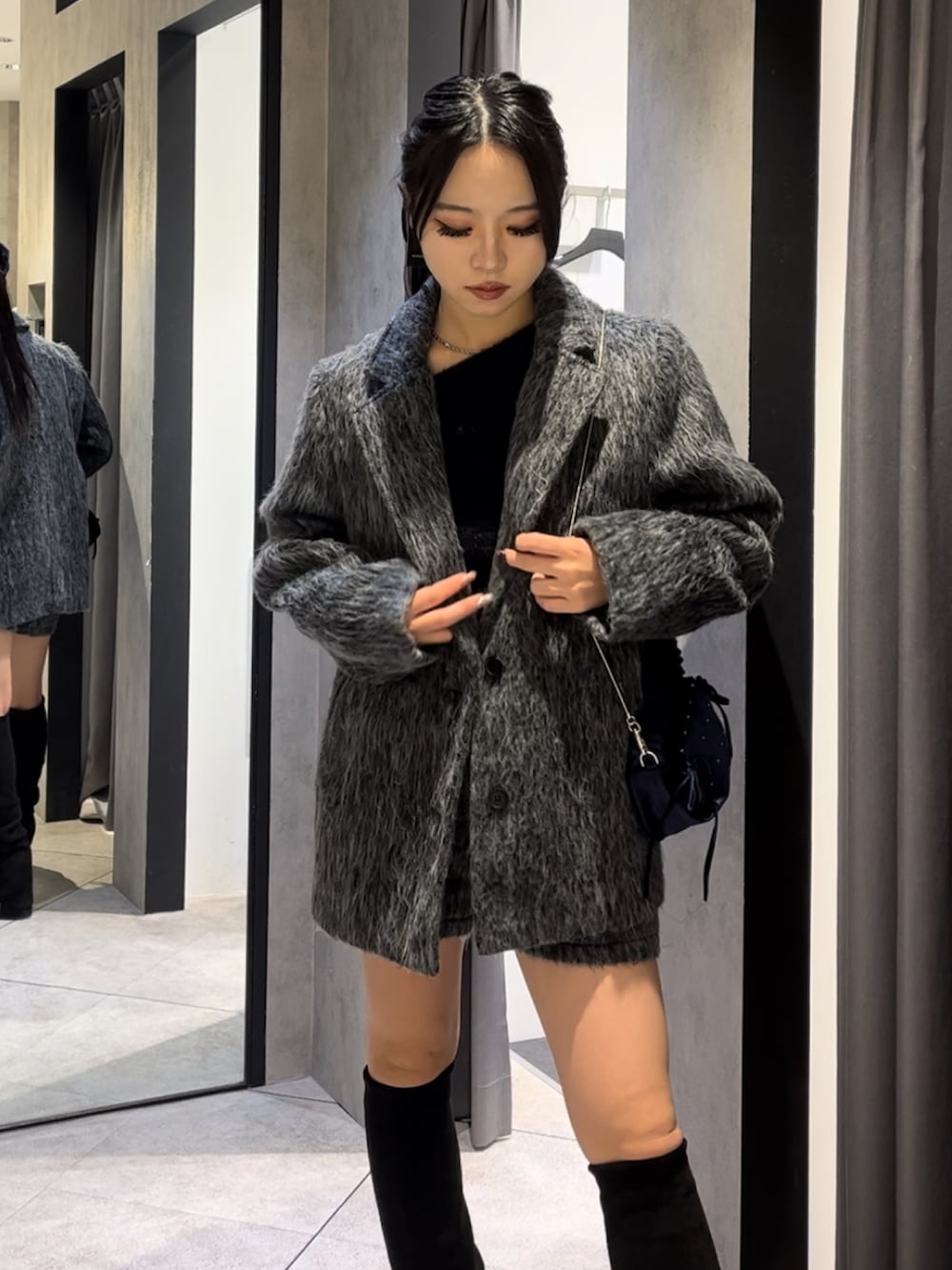 グレー系のその他アウター、ブラック系のニット/セーター、グレー系のその他パンツを着用したレディースの冬コーディネートの5枚目の写真