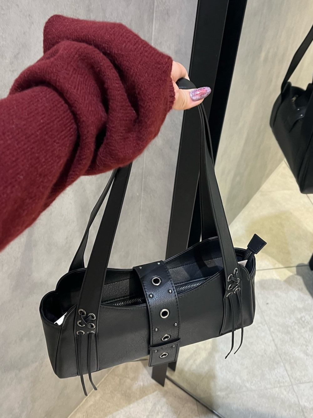 ブラック系のスカート、ブラック系のハンドバッグ、ブラック系のブーツを着用したレディースの秋コーディネートの10枚目の写真