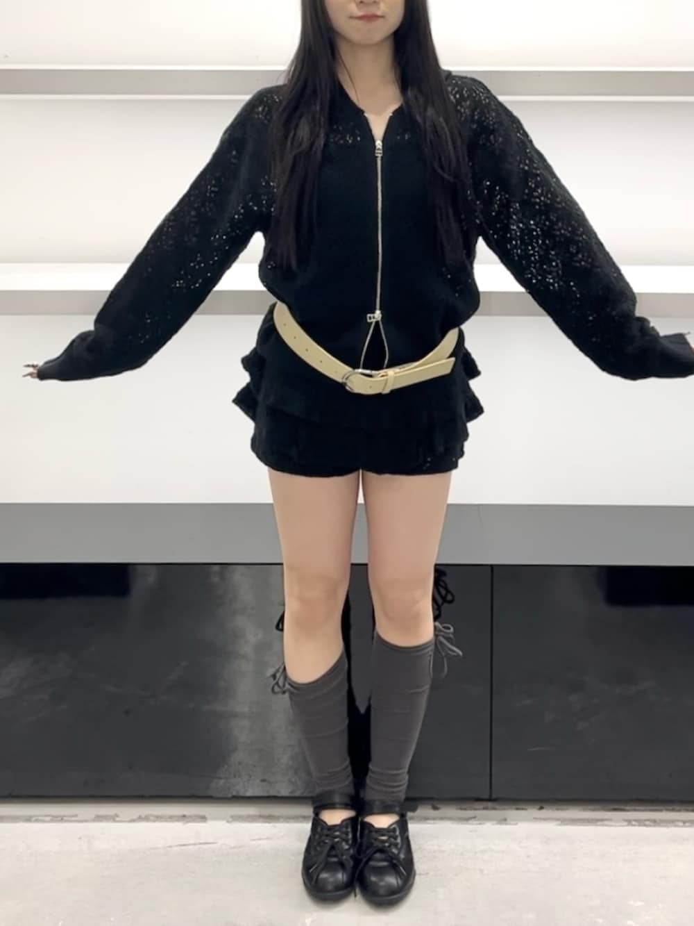 ブラック系のパーカー、ブラック系のスカート、ブラック系のスニーカーを着用したレディースの春コーディネートの5枚目の写真