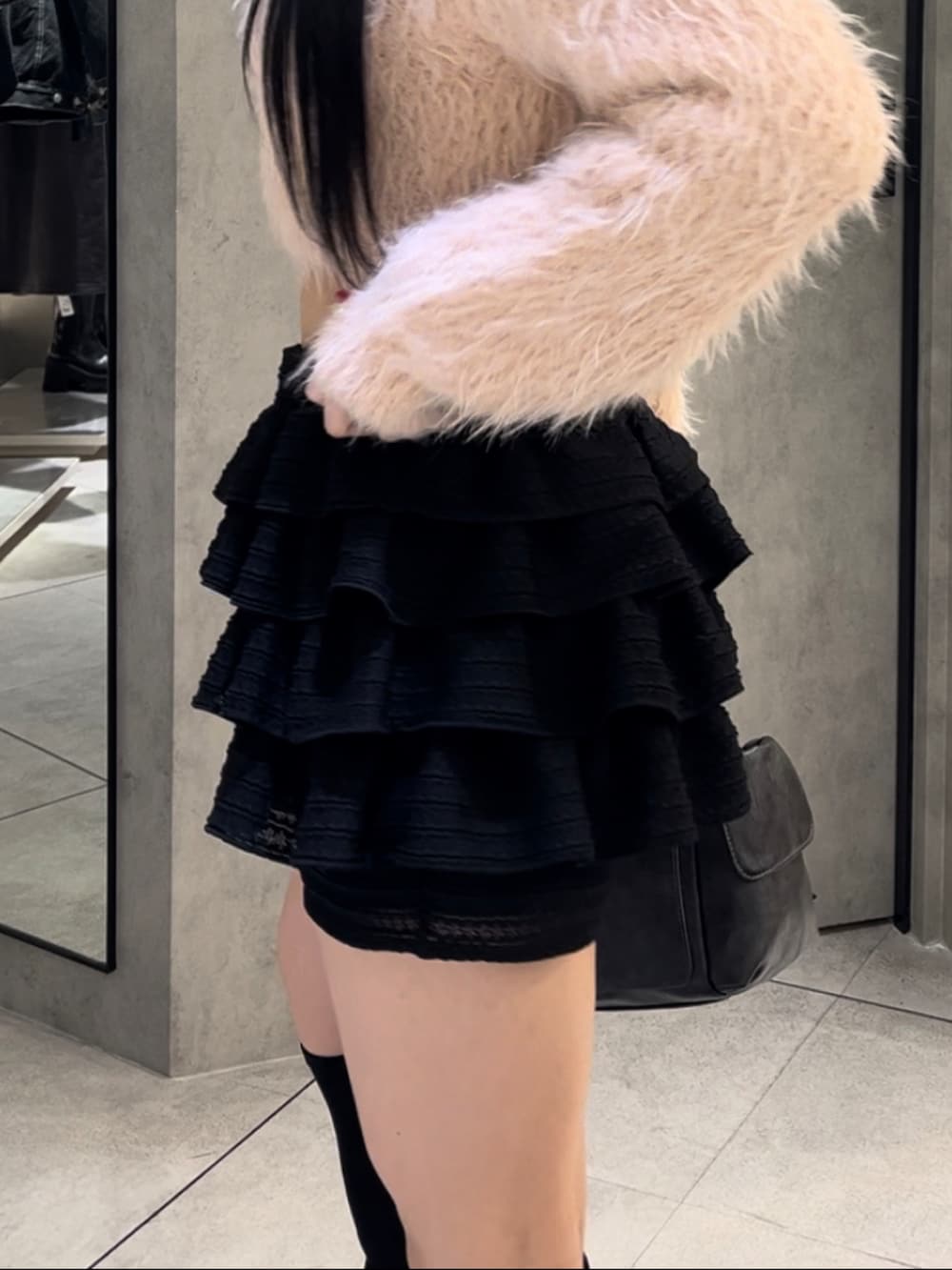 ピンク系のニット/セーター、ブラック系のハンドバッグ、ブラック系のその他パンツを着用したレディースの冬コーディネートの8枚目の写真