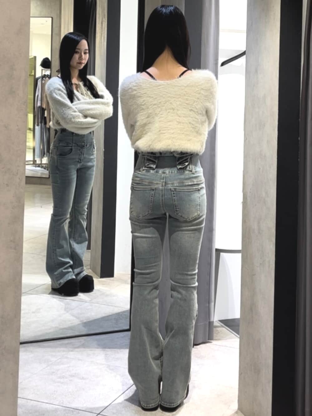 ブルー系のデニムパンツ、ホワイト系のニット/セーター、ブラック系のブーツを着用したレディースの冬コーディネートの3枚目の写真