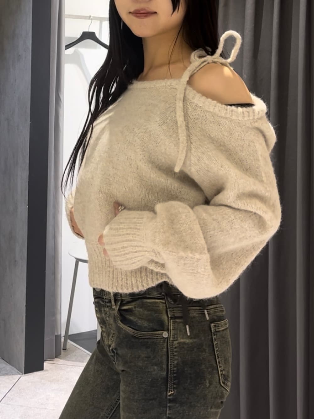 ブラウン系のダウンジャケット/コート、ホワイト系のニット/セーター、ブルー系のデニムパンツを着用したレディースの冬コーディネートの5枚目の写真