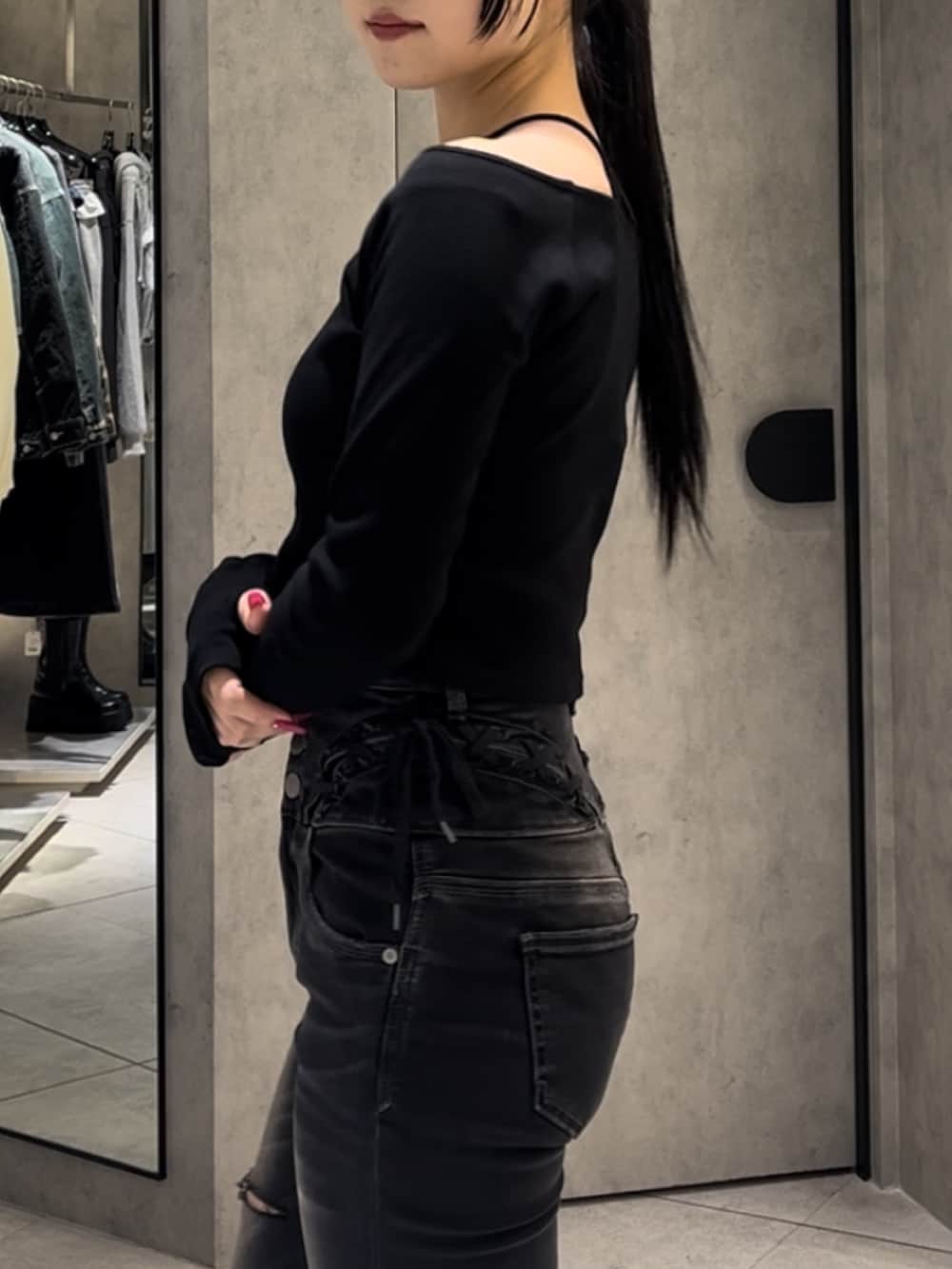 ブラック系のTシャツ/カットソー、ブラック系のデニムパンツ、ブラック系のブーツを着用したレディースの冬コーディネートの6枚目の写真