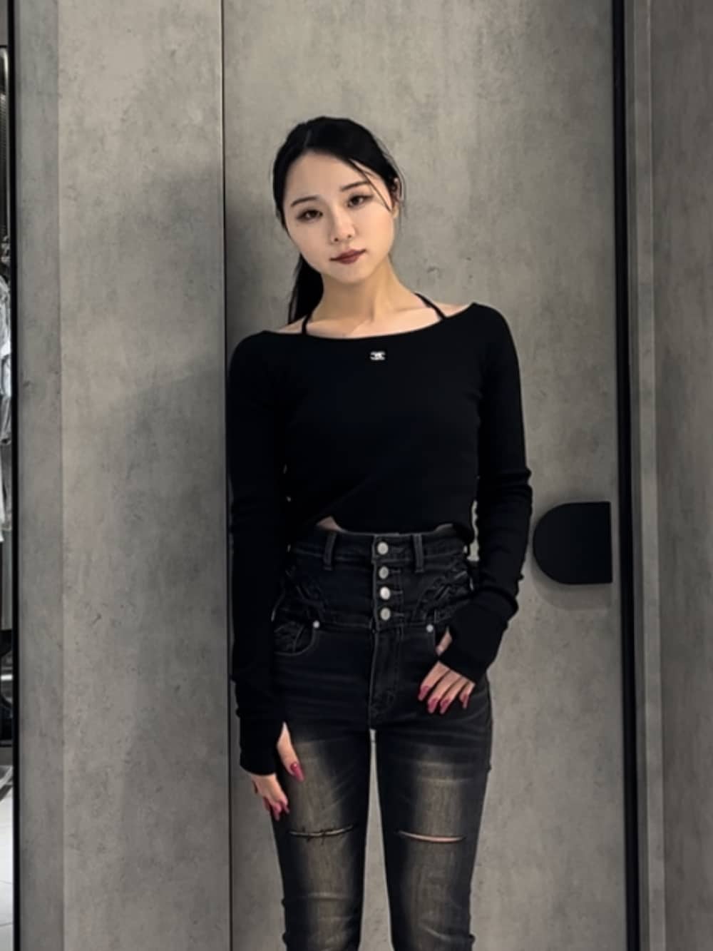 ブラック系のTシャツ/カットソー、ブラック系のデニムパンツ、ブラック系のブーツを着用したレディースの冬コーディネートの7枚目の写真