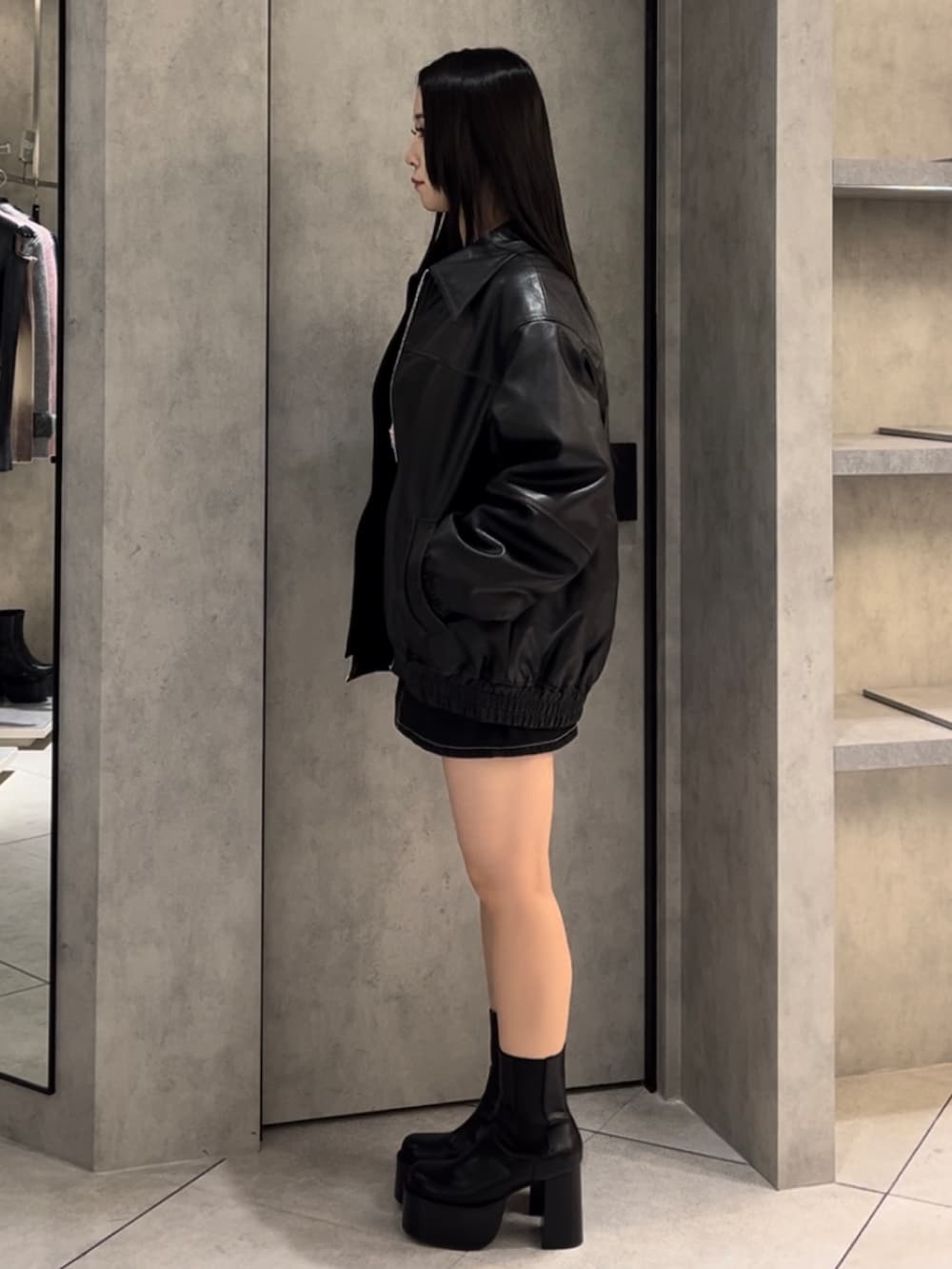 ブラック系のブルゾン、ピンク系のTシャツ/カットソー、ブルー系のスカートを着用したレディースの冬コーディネートの2枚目の写真