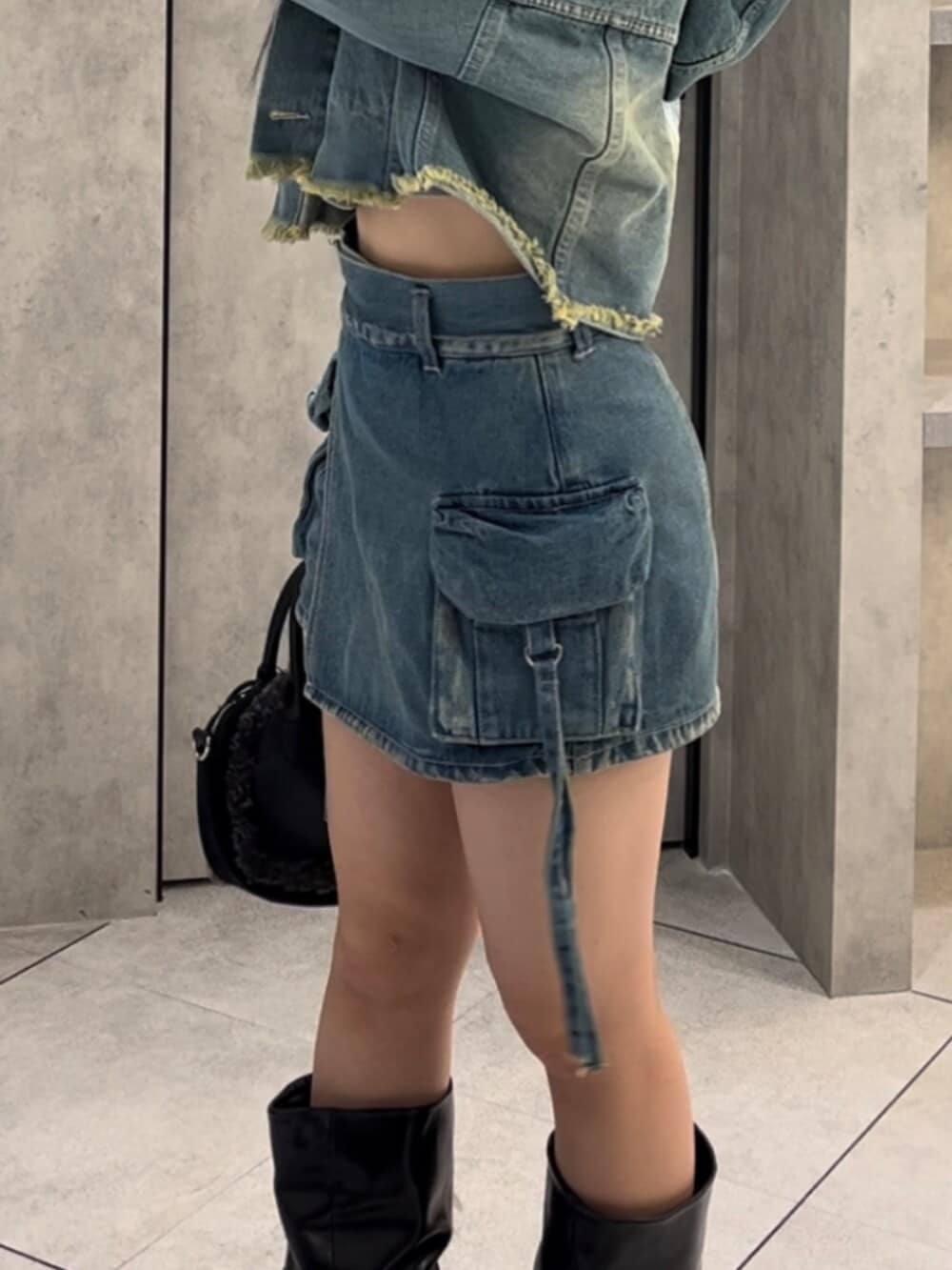 ブラック系のボストンバッグ、ブラック系のブーツ、ブルー系のデニムジャケットを着用したレディースの冬コーディネートの9枚目の写真