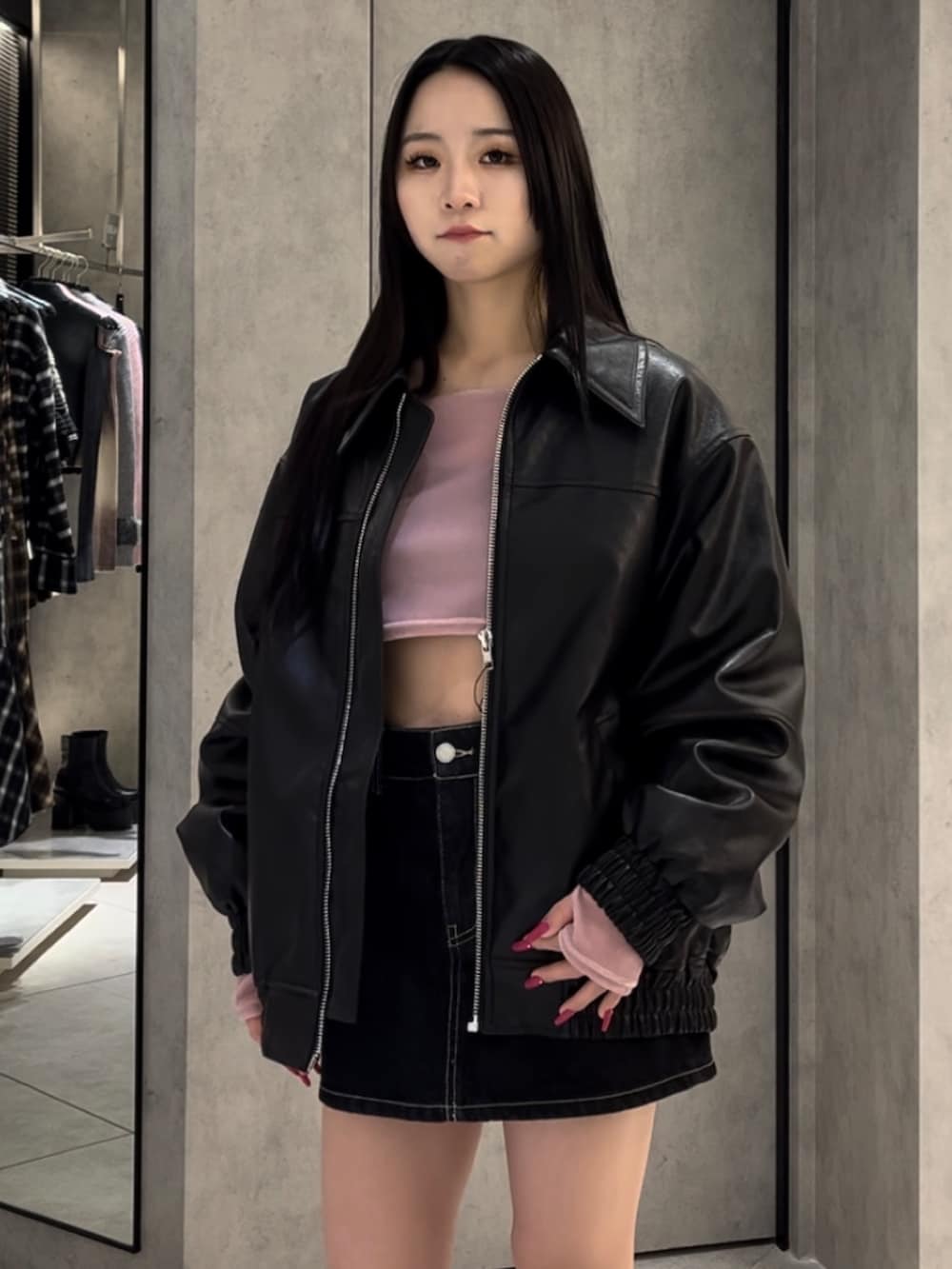 ブラック系のブルゾン、ピンク系のTシャツ/カットソー、ブルー系のスカートを着用したレディースの冬コーディネートの4枚目の写真