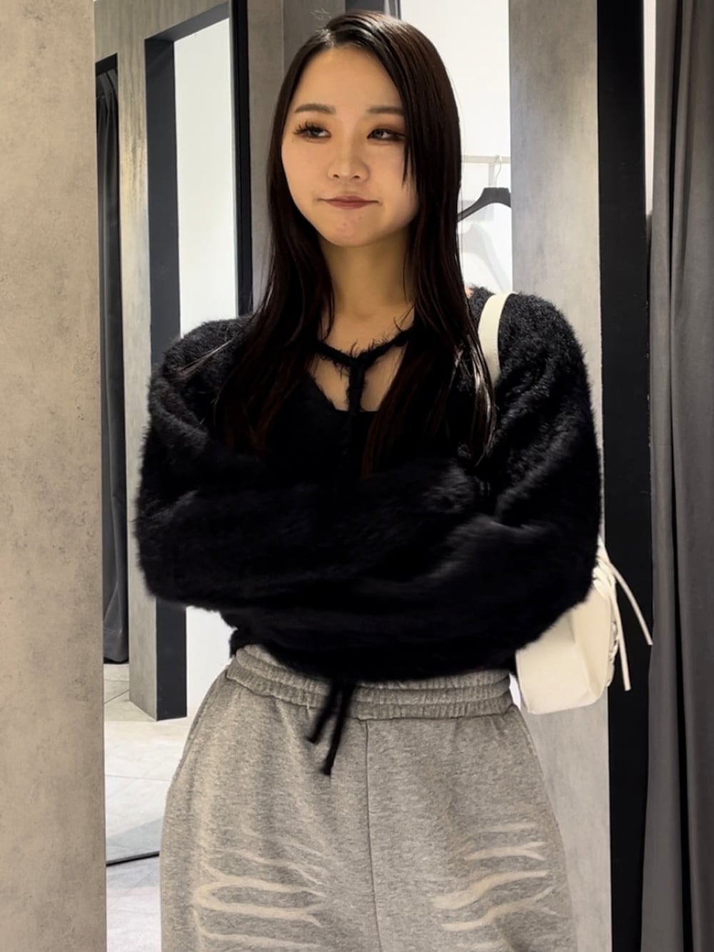 ブラック系のニット/セーター、グレー系のスウェットパンツ、ホワイト系のショルダーバッグを着用したレディースの冬コーディネートの4枚目の写真