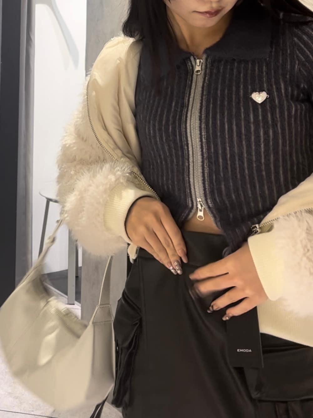 ホワイト系のブルゾン、ブルー系のニット/セーター、ブラック系のその他パンツを着用したレディースの冬コーディネートの10枚目の写真