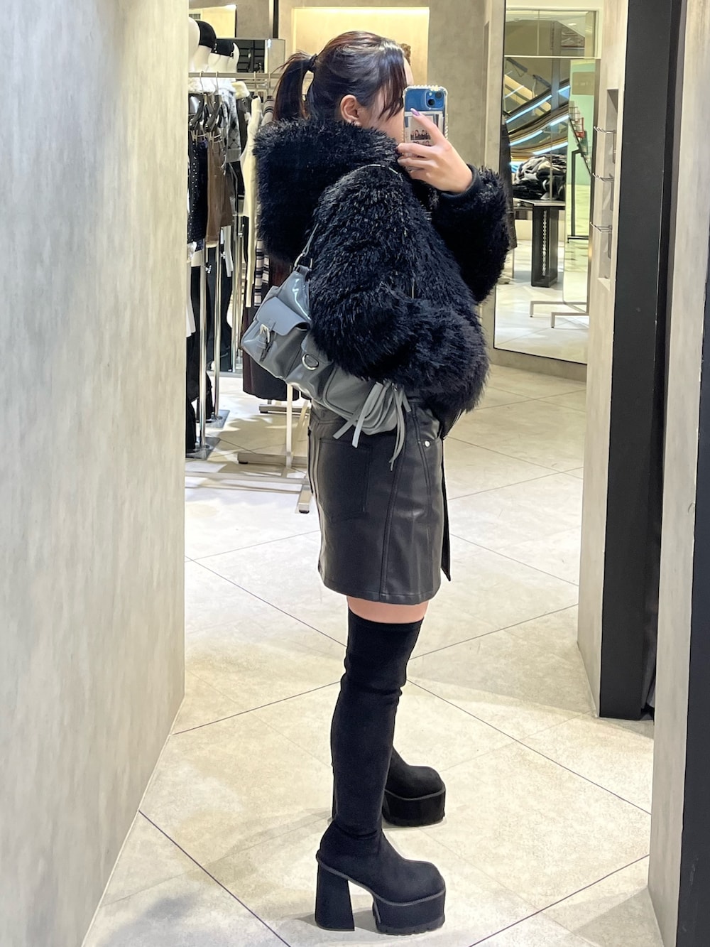 ブラック系のブーツ、グレー系のハンドバッグ、ブラック系のスカートを着用したレディースの秋コーディネートの4枚目の写真